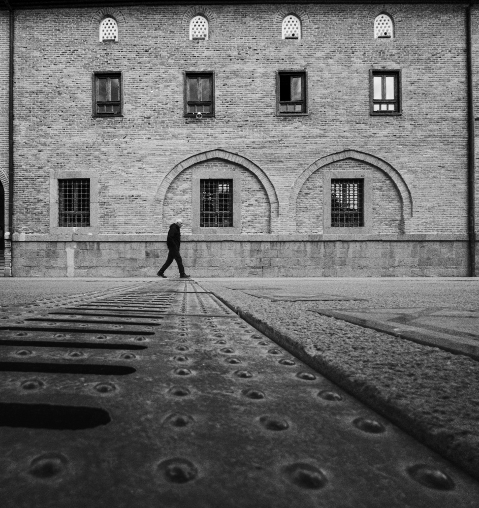 Lone Figure Brick Building by Doruk Uysal — canvas wall art