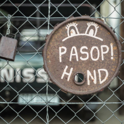 Warning Sign On A Rusty Wheel Cover