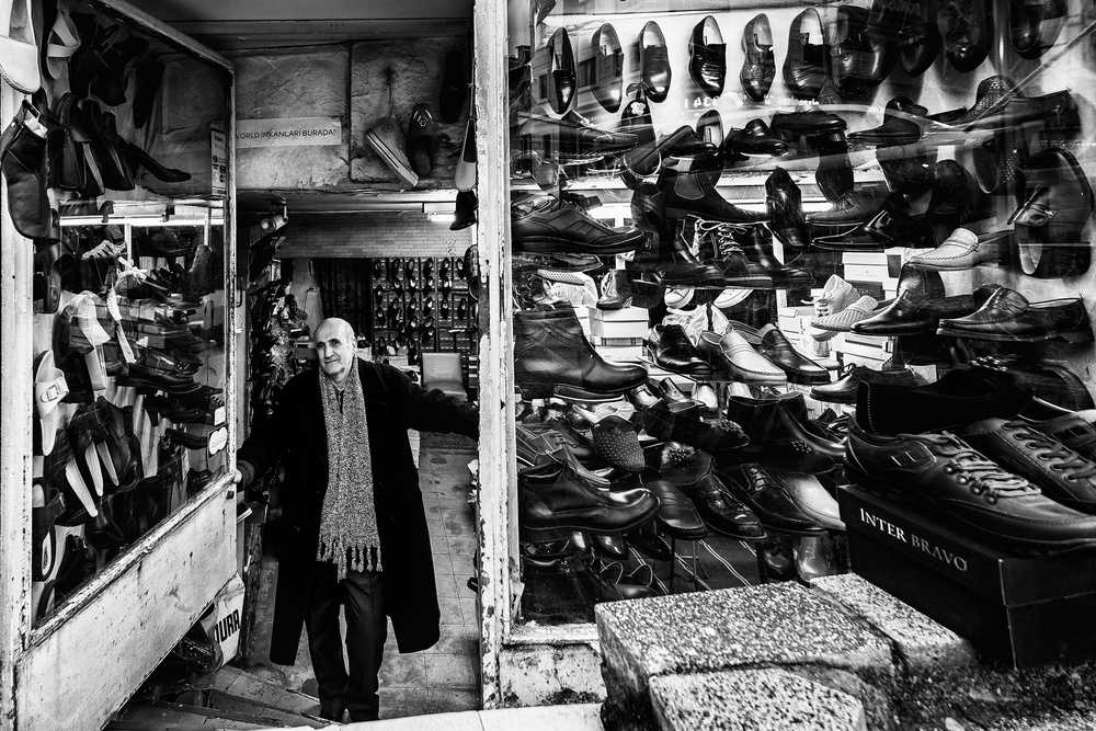Smiling Shoe Shopkeeper by Yavuz Pancareken — canvas wall art