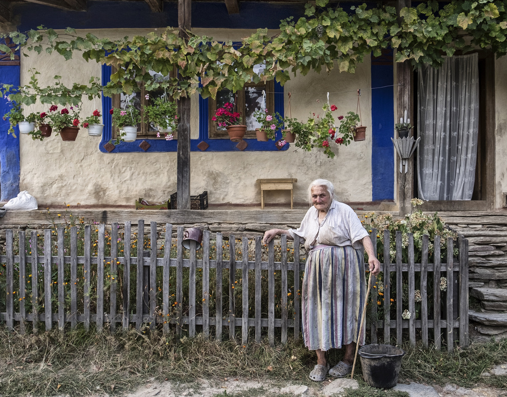 Elderly Woman Village Home by Andrei Nicolas - The Traveler — canvas wall art