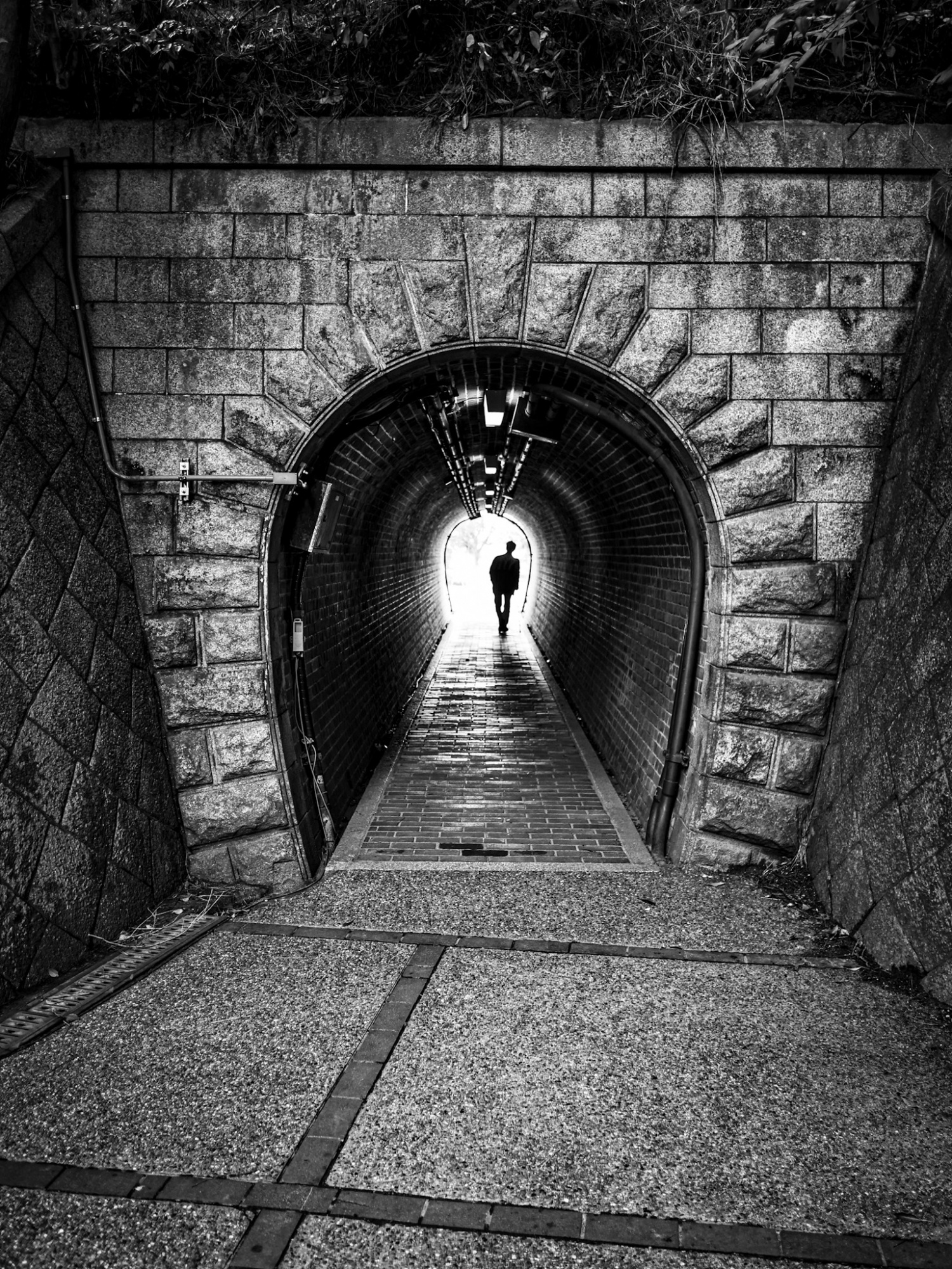 A man passing through a small tunnel