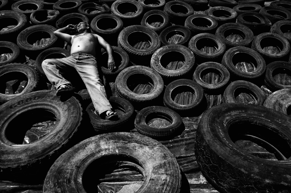 Man Amidst Tires by Miki Meir Levi — canvas wall art