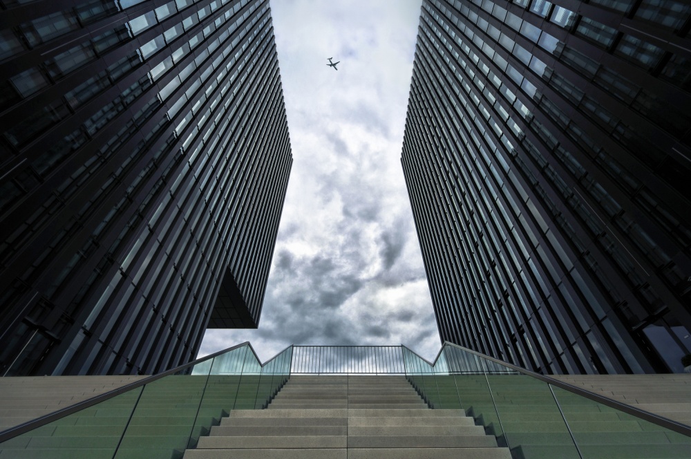 Skyscrapers Above Cloudy Sky by Ercan Sahin — canvas wall art